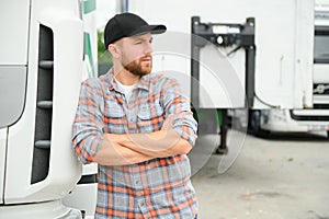 Portrait of trucker standing by his truck ready for driving. Driver occupation. Transportation services