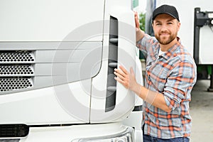 Portrait of trucker standing by his truck ready for driving. Driver occupation. Transportation services