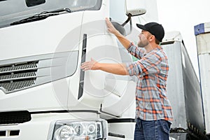 Portrait of trucker standing by his truck ready for driving. Driver occupation. Transportation services