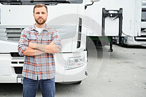 Portrait of trucker standing by his truck ready for driving. Driver occupation. Transportation services