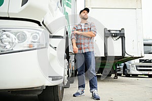 Portrait of trucker standing by his truck ready for driving. Driver occupation. Transportation services