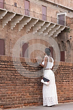 Portrait of turist woman dressed in white getting to know Europe, Ferrara. Italy