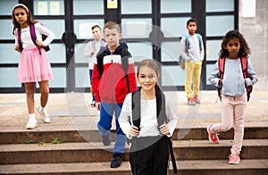 Tweenager girl with backpack walking after lessons photo