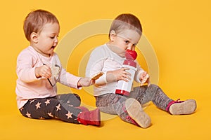 A portrait of two adorable beautiful children share delicious food together, make friends, enjoy moments of their childhood.