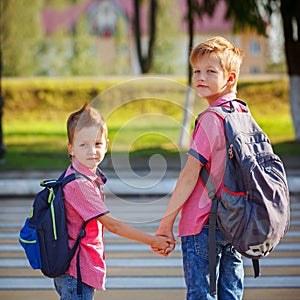 Portrait two adorable boys with backpack near pedestrian crossin.