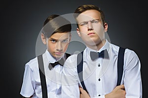 Portrait of two angry boys isolated on gray background. Negative human emotion, facial expression. Closeup