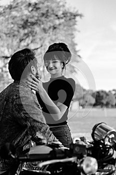 Portrait of two Attractive Good Looking Young Adult Modern Fashionable People Guy Girl Couple on Classic Green Motorcycle Hugging