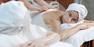 Two beautiful young woman having back massage. Front view. Tranquility.