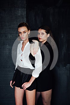 Portrait of two beautiful fashionable brunette women and blonde in black white clothes