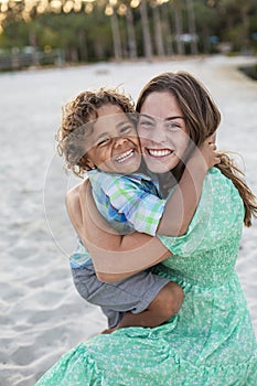 Portrait of two beautiful diverse children smiling and hugging each other.