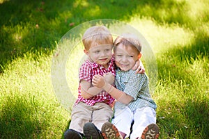 Portrait of two boys embracing and laughing outdoors