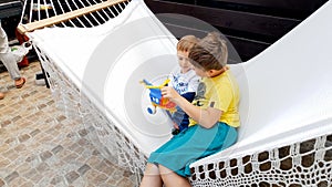 Portrait of two boys lying on the hammock at house backyard