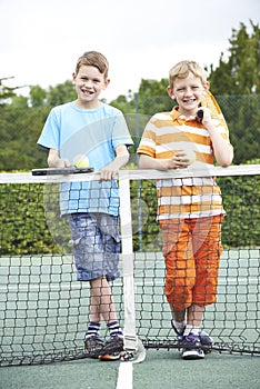 Portrait Of Two Boys Playing Tennis Together