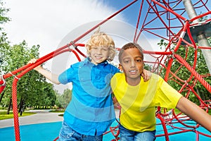 Portrait of two boys stand on red ropes