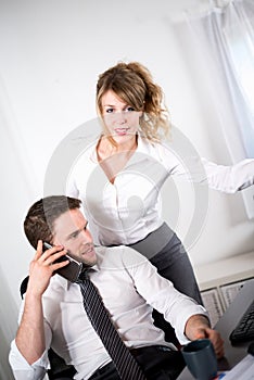 Portrait of two business people working together in office with computer