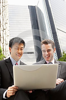 Portrait Of Two Businessmen Working On Laptop