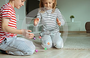 Portrait of two cheerful children laying on the floor and playing with colorful dices