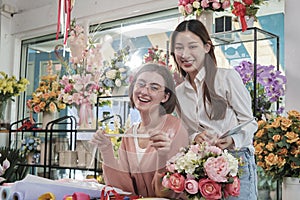 Two young women florist partners with a happy smile in a flower shop.