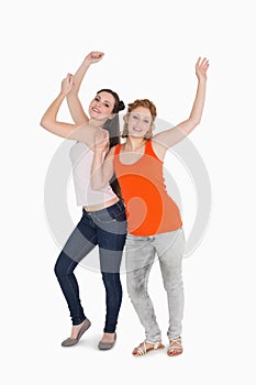 Portrait of two cheerful young female friends dancing