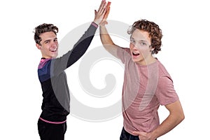 Portrait of a two cheerful young men celebrating isolated over white background