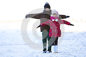 Portrait of two children boy and girl playing outdoors in winter