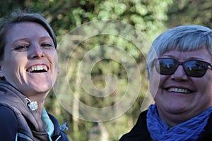 A portrait of two collegue ladies in the nature laughing