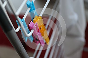 A portrait of two colorful washingpins hanging on a laundry rack without any wet clothes on it to dry