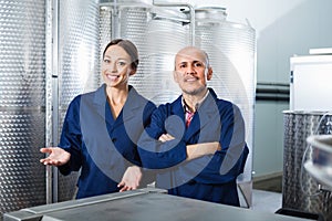 Portrait two coworkers standing on wine factory