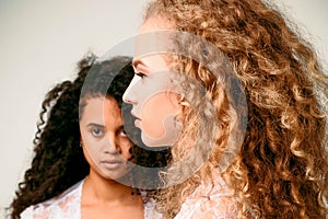 Portrait of two curly girls. Afro and blond