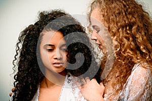 Portrait of two curly girls. Afro and blond