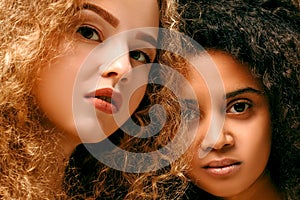 Portrait of two curly girls. Afro and blond