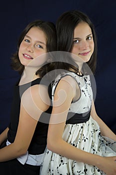 Portrait of two cute sisters back to back