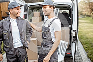 Portrait of a two delivery company employees, delivering goods by car