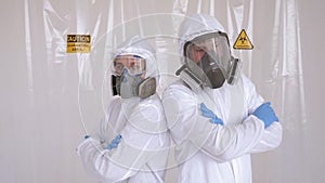 Portrait of two doctors in medical suits, respirators in the hospital. COVID-19.