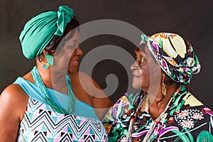 Portrait of two elderly African American sisters looking at each other affectionately