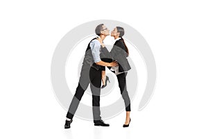 Portrait of two employees, managers in official suit kissing isolated over white background. Office romance