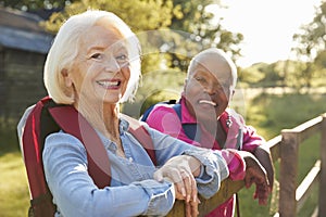 Portrait Of Two Female Senior Friends Hiking In Countryside