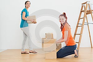 Portrait of two friends moving together in a new house
