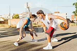 Portrait of two friends playing basketball on court.