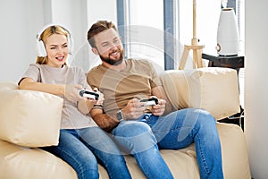 Portrait of two friends playing video games at home. Lifestyle and technology concept.