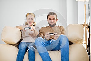 Portrait of two friends playing video games at home. Lifestyle and technology concept.