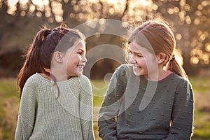 Portrait Of Two Girls Outdoors Laughing And Talking Together