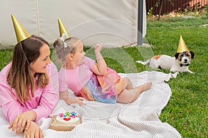 Portrait of two girls sisters celebrating their dog's Jack Russell Terrier pet birthday