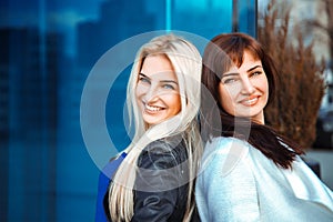 Portrait of two glamour ladies blonde and brunette looking at th