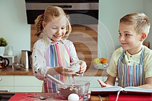 Portrait of two happy children which having fun during cooking c