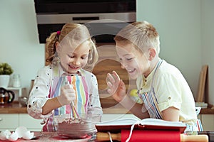 Portrait of two happy children which having fun during cooking c