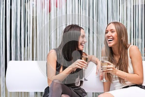 Portrait of two happy girl with champagne