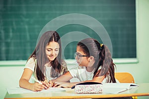 Portrait of two happy schoolgirls in a classroom