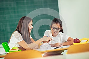 Portrait of two happy schoolgirls in a classroom