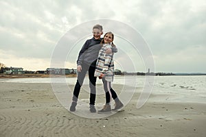 Portrait of two happy teenager siblings children walking and having fun on Baltic sea beach